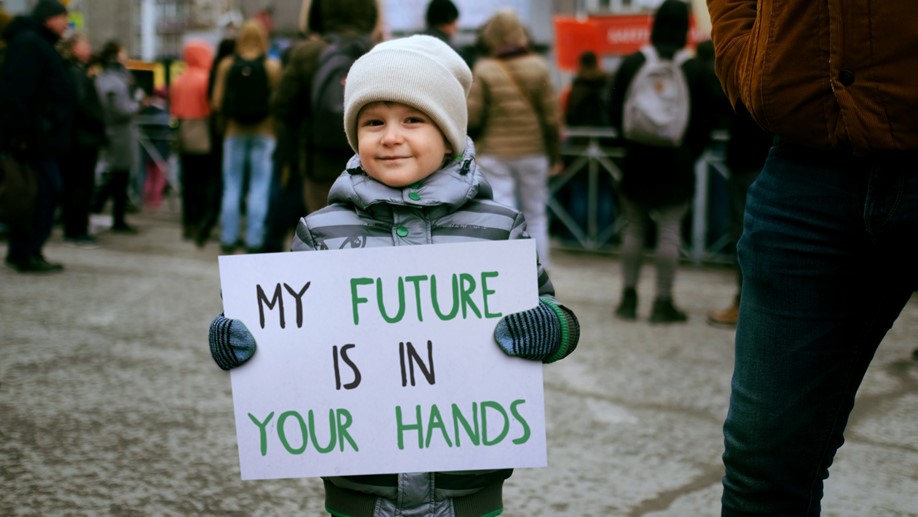 Child at protest holding sign that says "my future is in your hands"