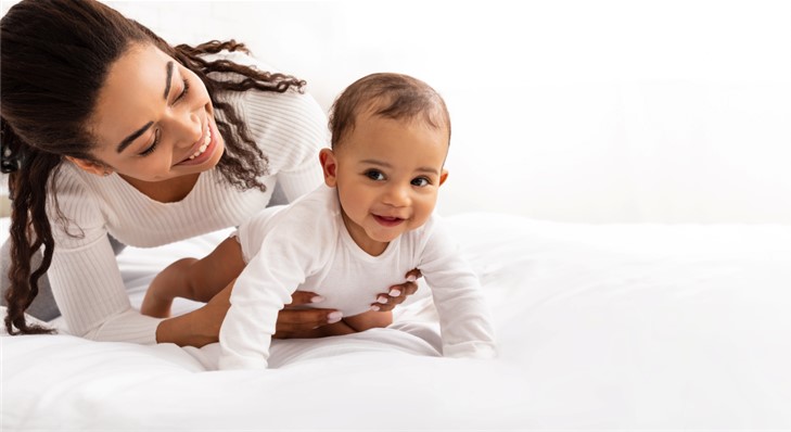 Mom holding baby who is crawling