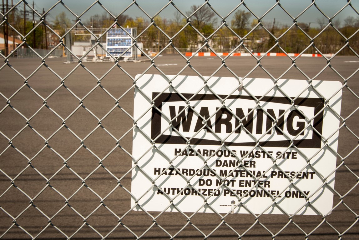 Warning sign on fence at superfund site