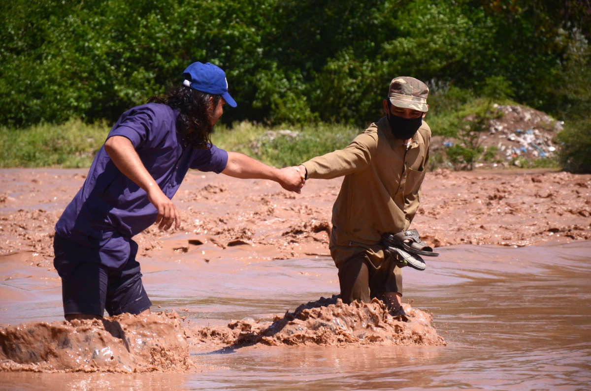 People walk in flood water after a heavy rainfall in Peshawar, Pakistan, on April 15, 2020.