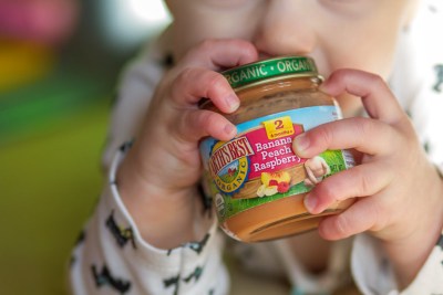 Baby holding a jar of baby food