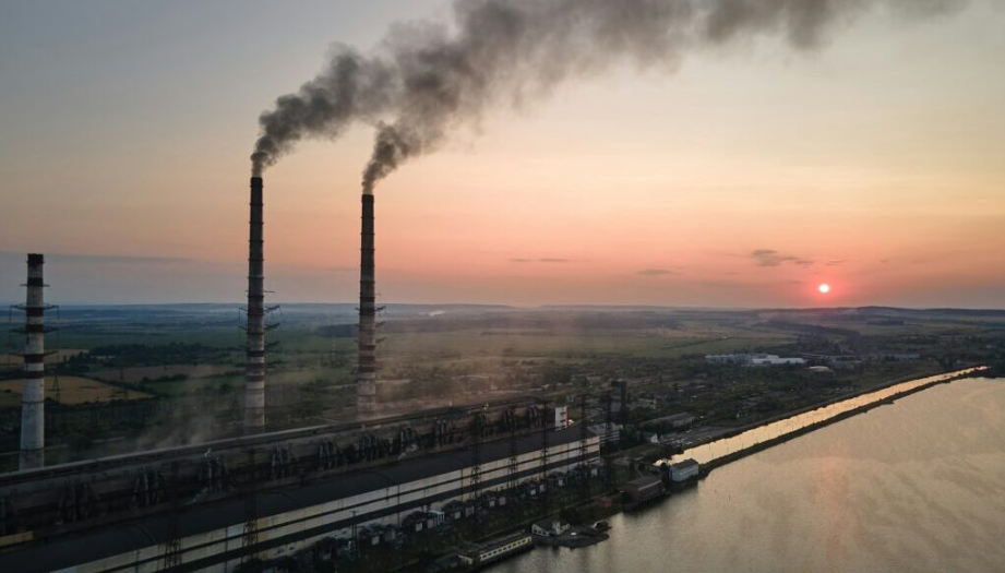 Factory smokestacks with smoke coming out of them