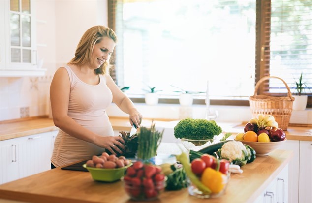 Pregnant woman chopping vegetables