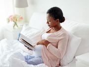 Pregnant woman reading in bed