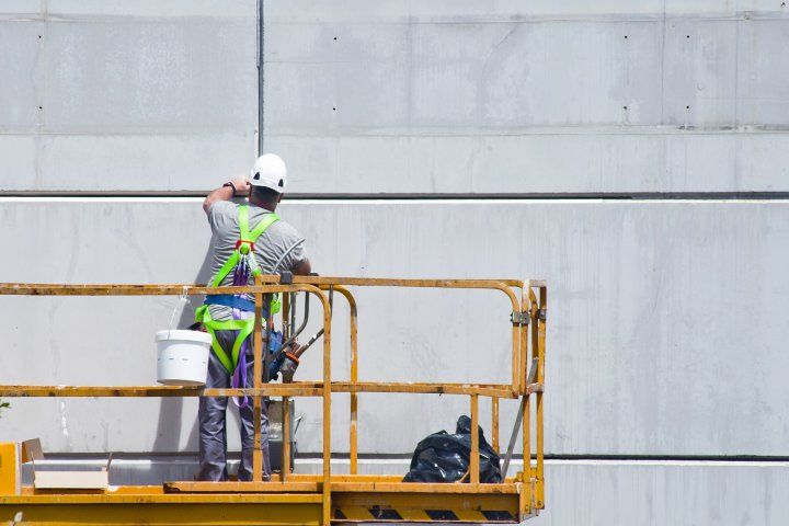 Construction worker cleaning off paint
