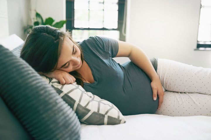 Pregnant women sleeping on a bed