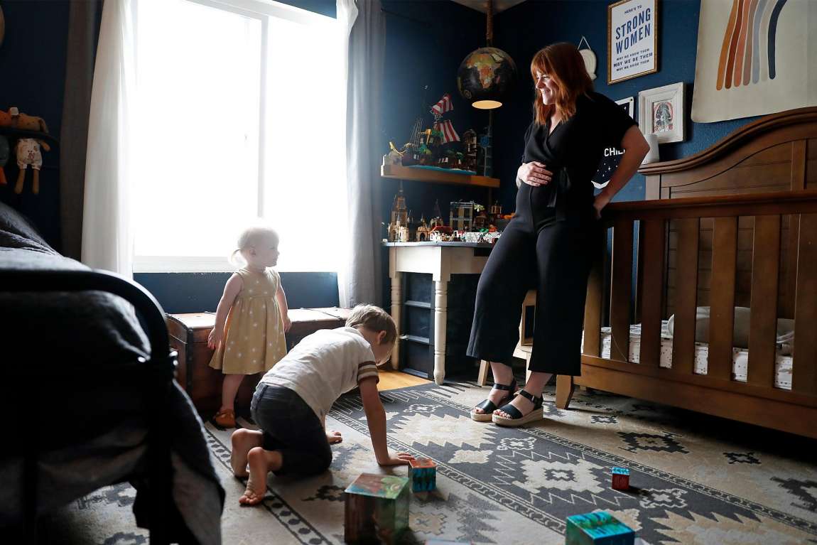 Pregnant women watching her two kids play