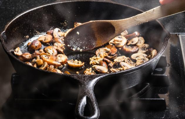 Mushrooms cooking in cast iron pan