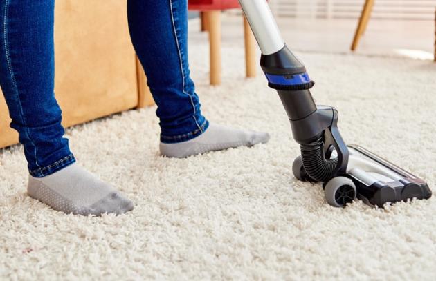 Person vacuuming carpet