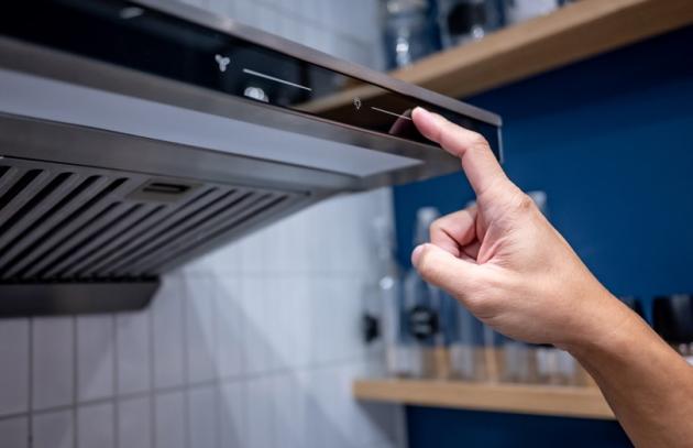 Hand turning on stove fan