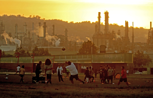 Kids playing soccer next to factory