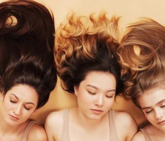 Three women laying on the ground with their hair screeched out above them