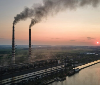 Factory smokestacks with smoke coming out of them